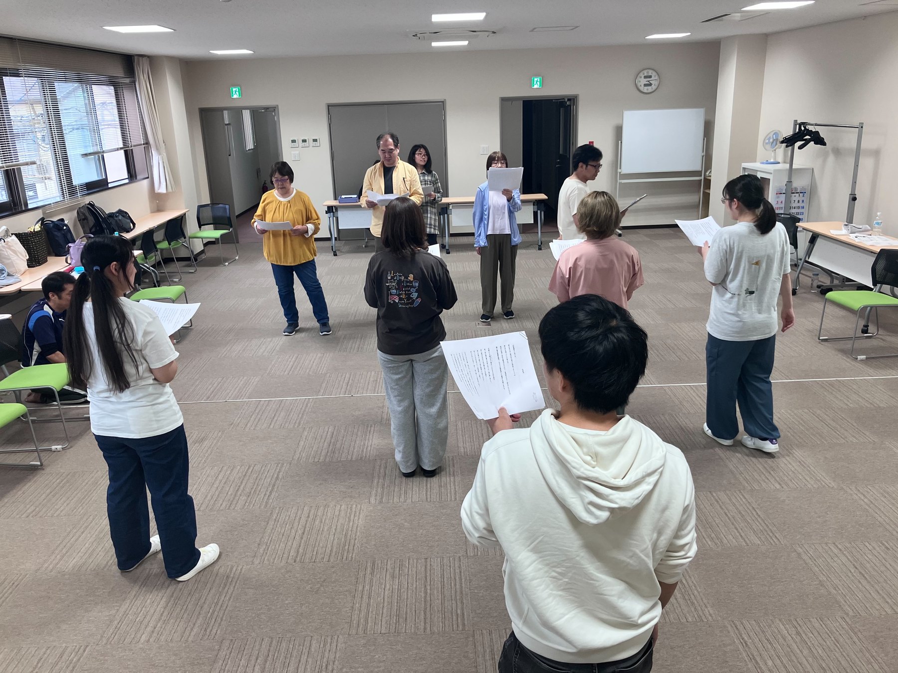 参加者が台本を手に向かい合って稽古する様子